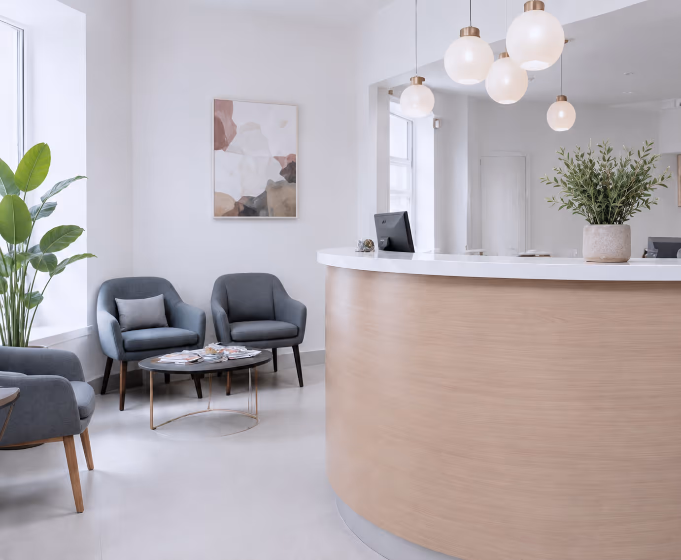 Modern waiting area with blue armchairs, round black coffee table, and curved wooden reception desk.