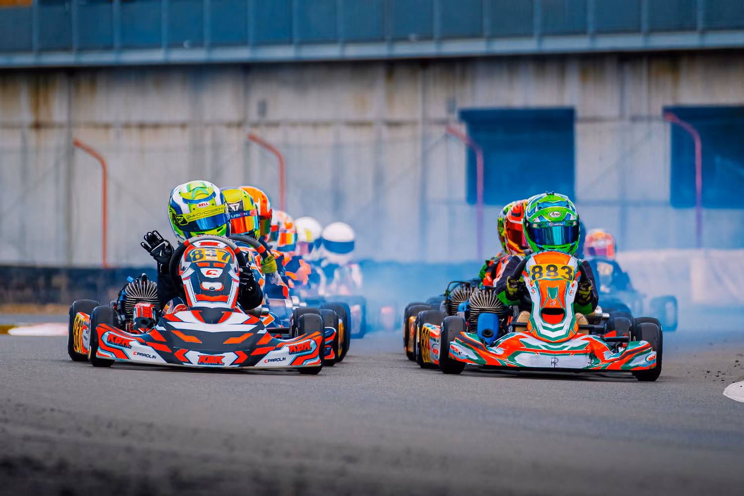 Karts leaving the start in a cloud of tyre smoke in Mariembourg