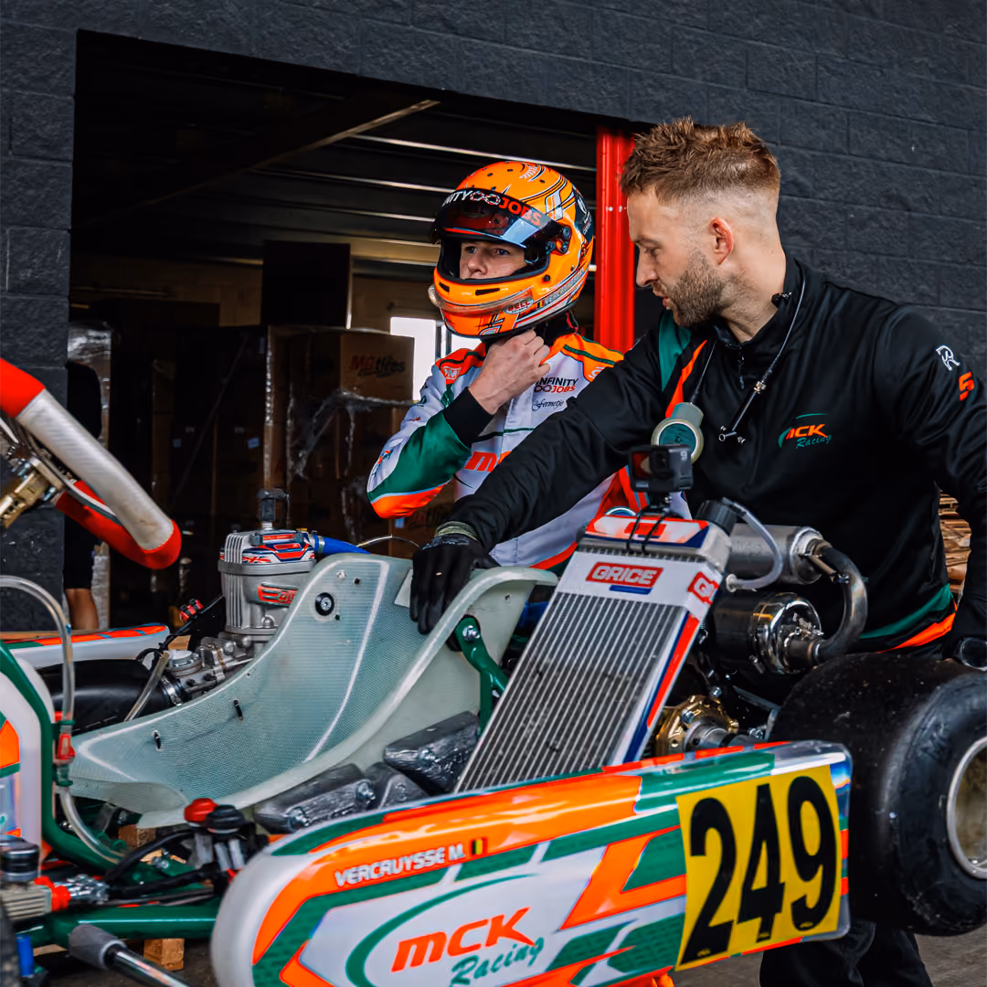 MCK Racing mechanic helping a driver in kart 249 in the pit box