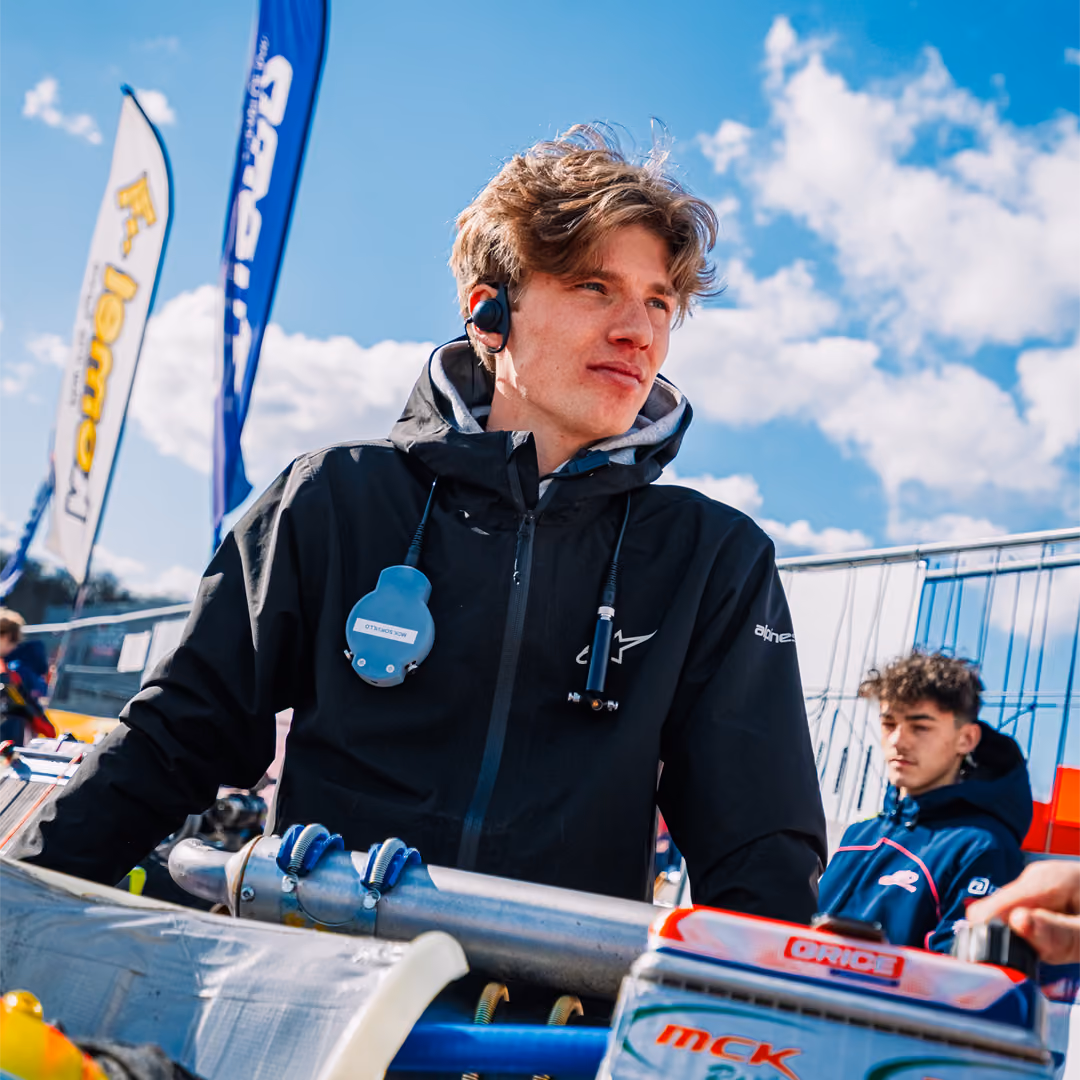 MCK Racing team member with headset next to a kart