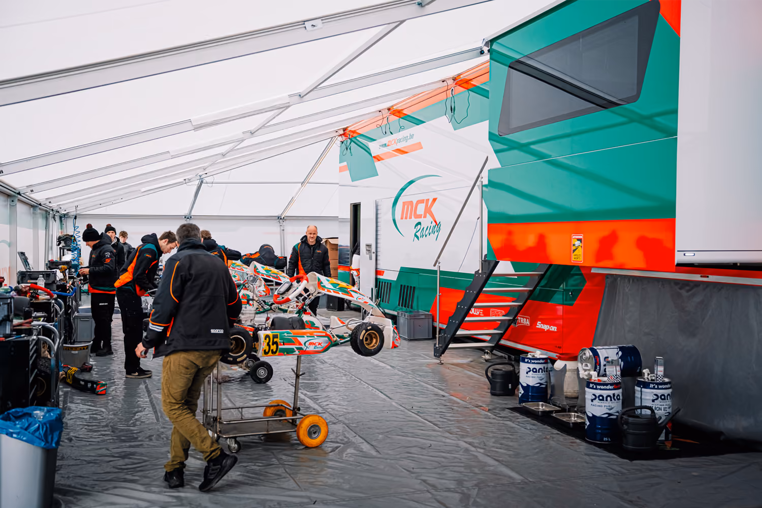 MCK Racing team tent in the paddock with karts and mechanics
