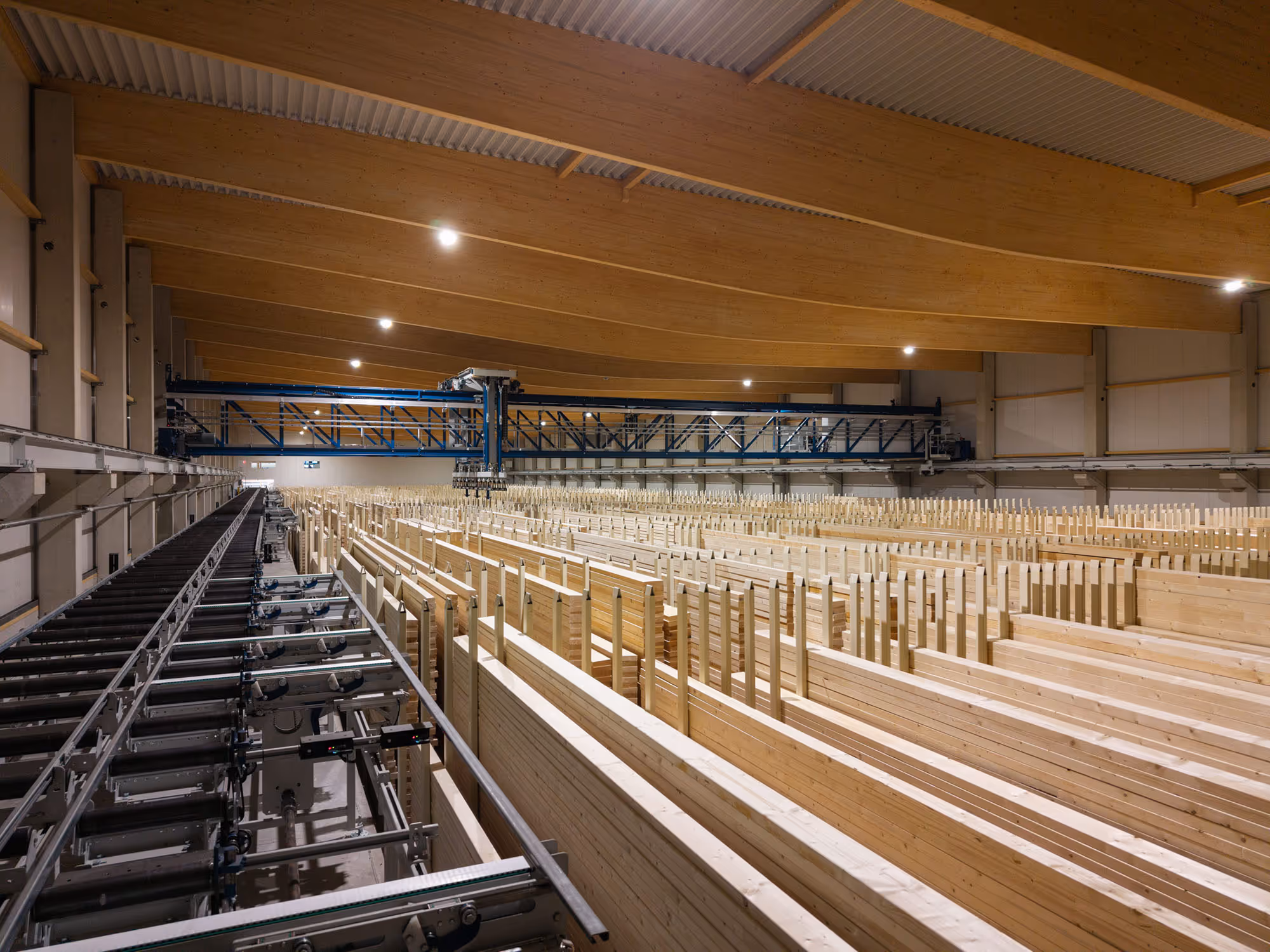 Ein Blick in die Lagerhalle mit Kran und vielen Lagerplätzen die vertikal angeordnet sind