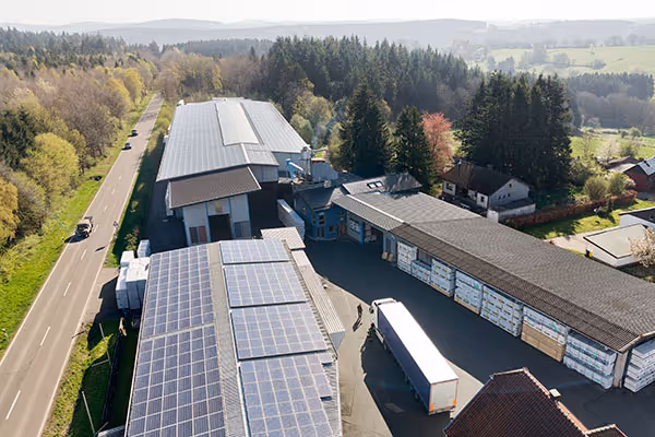 Eine Luftaufnahme des Standorts in Broich - lange Hallen sind zu erkennen, eine Straße links daneben und ein LKW der im Hof steht.