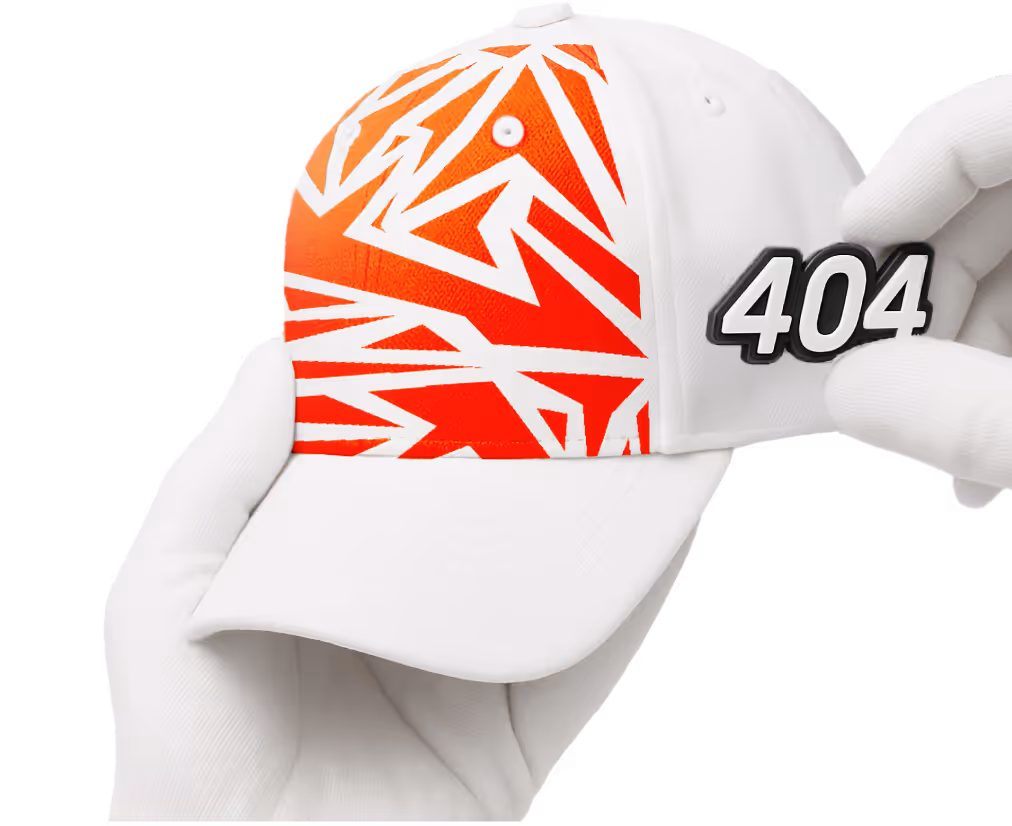 White baseball cap with an orange geometric pattern on the front panel, held by two hands wearing white gloves, with a removable black and white badge displaying the number 404.