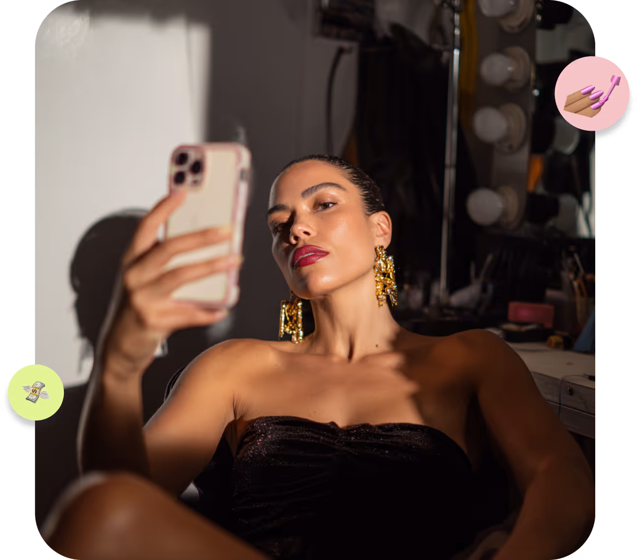 Mujer con labios rojos y pendientes dorados grandes toma una selfie con móvil en cuarto oscuro con luces de tocador.