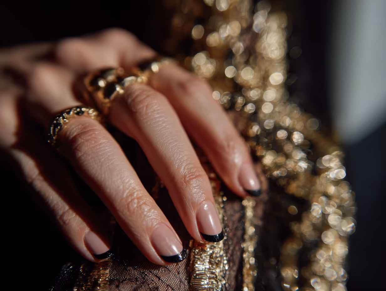 Close-up of a hand with glossy white almond-shaped nails against a light background.