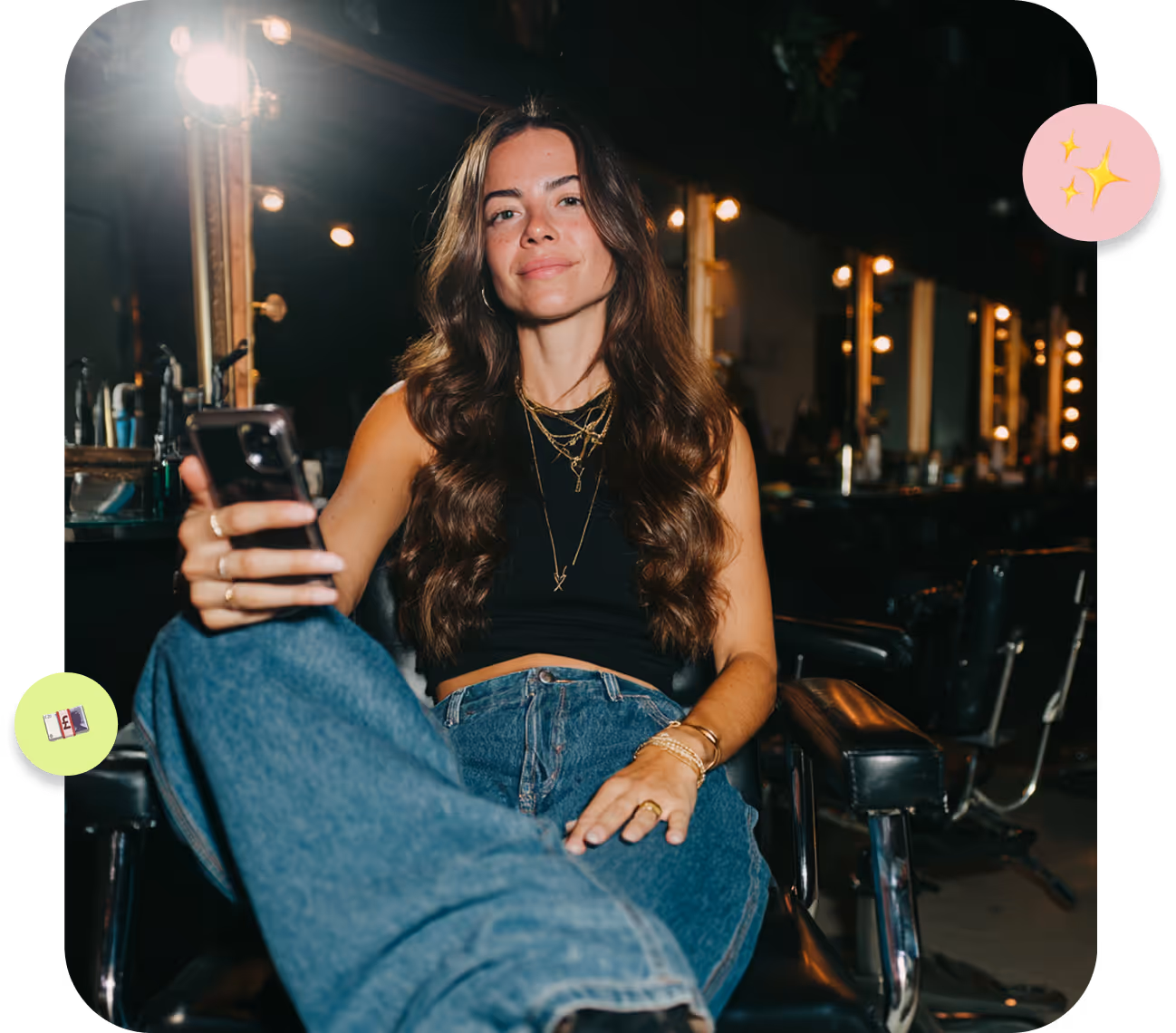 Tattooed woman wearing black gloves performing a facial treatment on a patient lying down with a pink headband and fuzzy sweater in a spa room with pink lighting.