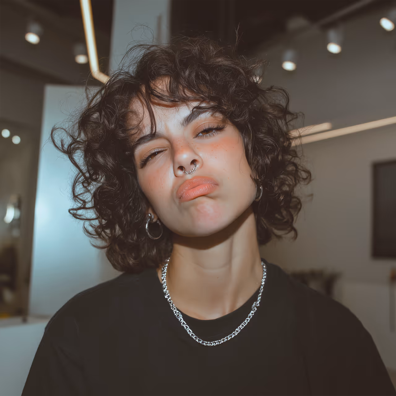 Close-up of a hand with glossy white almond-shaped nails against a light background.
