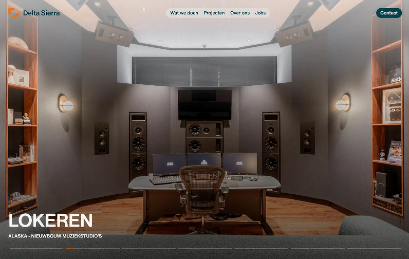 Interieur van een moderne muziekstudio met mengpaneel, drie computerschermen en grote speakers tegen de muren.