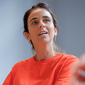 Een vrouw met een rode blouse die het uitleg.