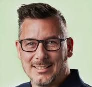 Een man met bril die fier lacht.