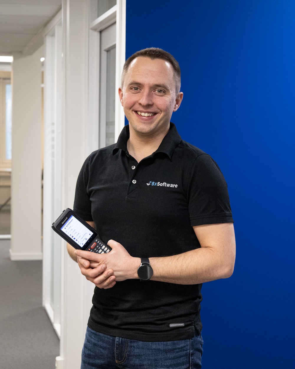 Ansatt i BxSoftware, med håndterminalen klar til å vise deg hvordan du effektiviserer lageret med BxLogistics