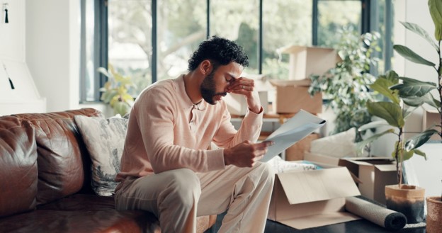 Business owner stressed while checking freight invoice charges during an office move.