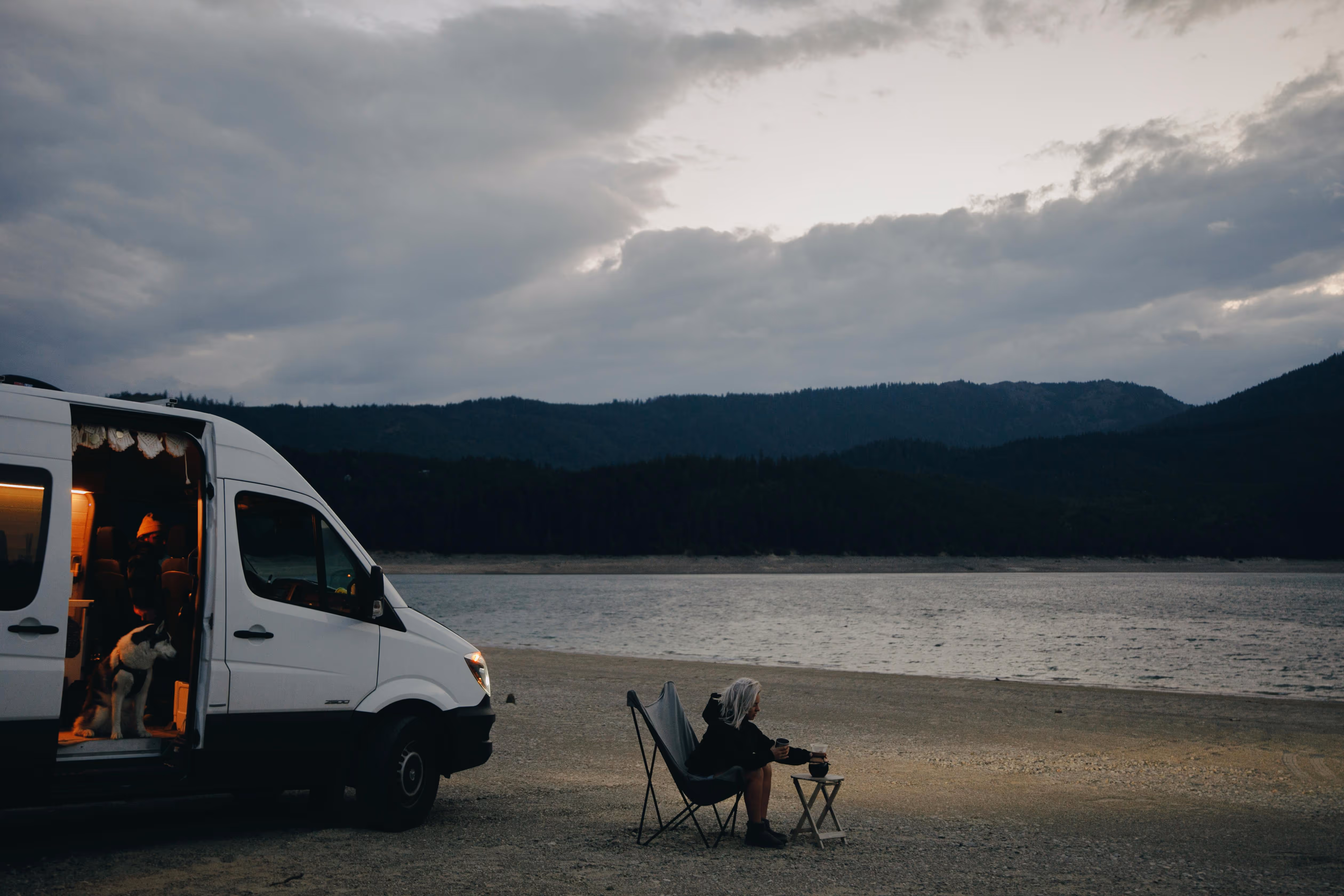 Campervan parked beside lake during off-grid travel