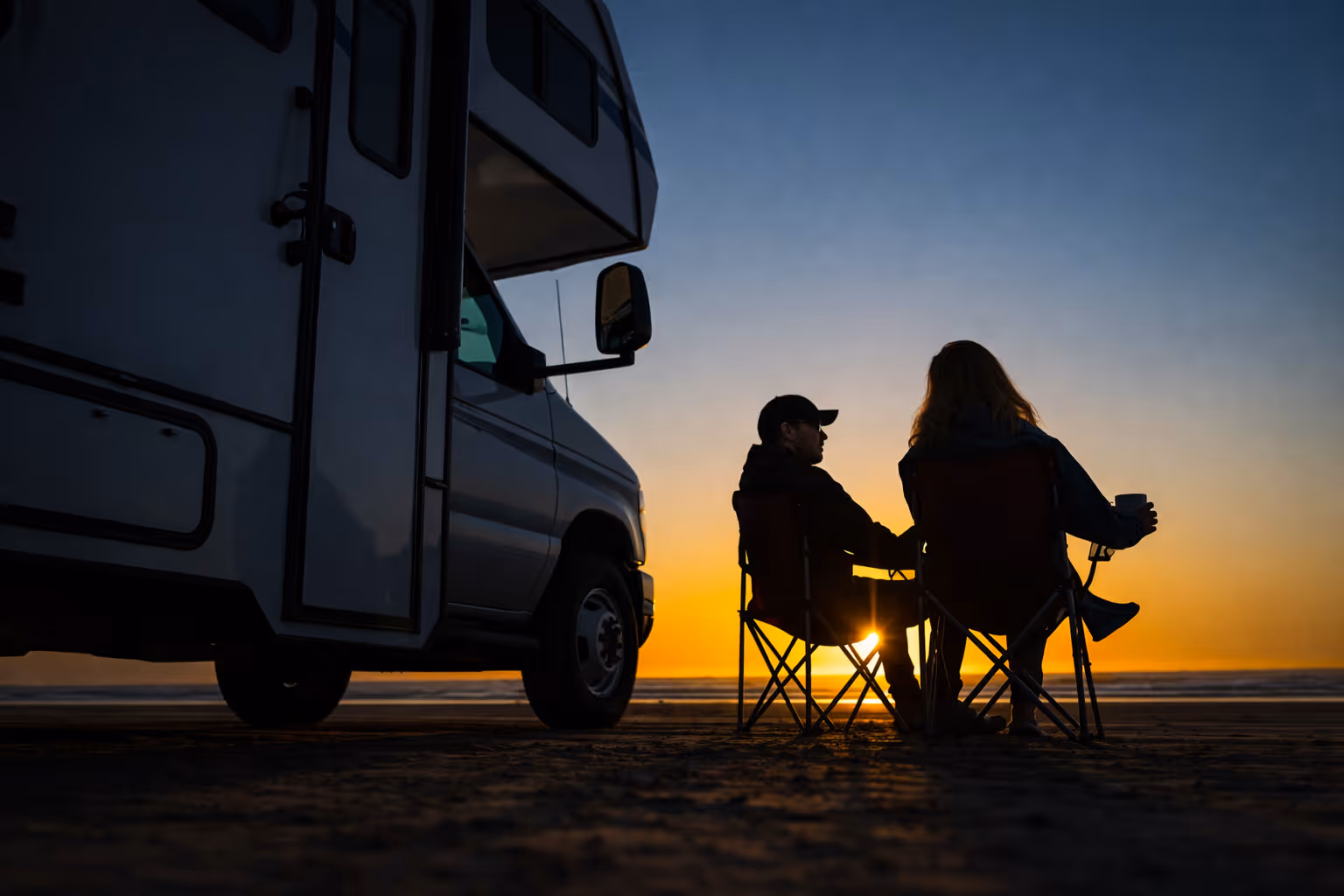 Motorhome campsite at night with outdoor seating and lights