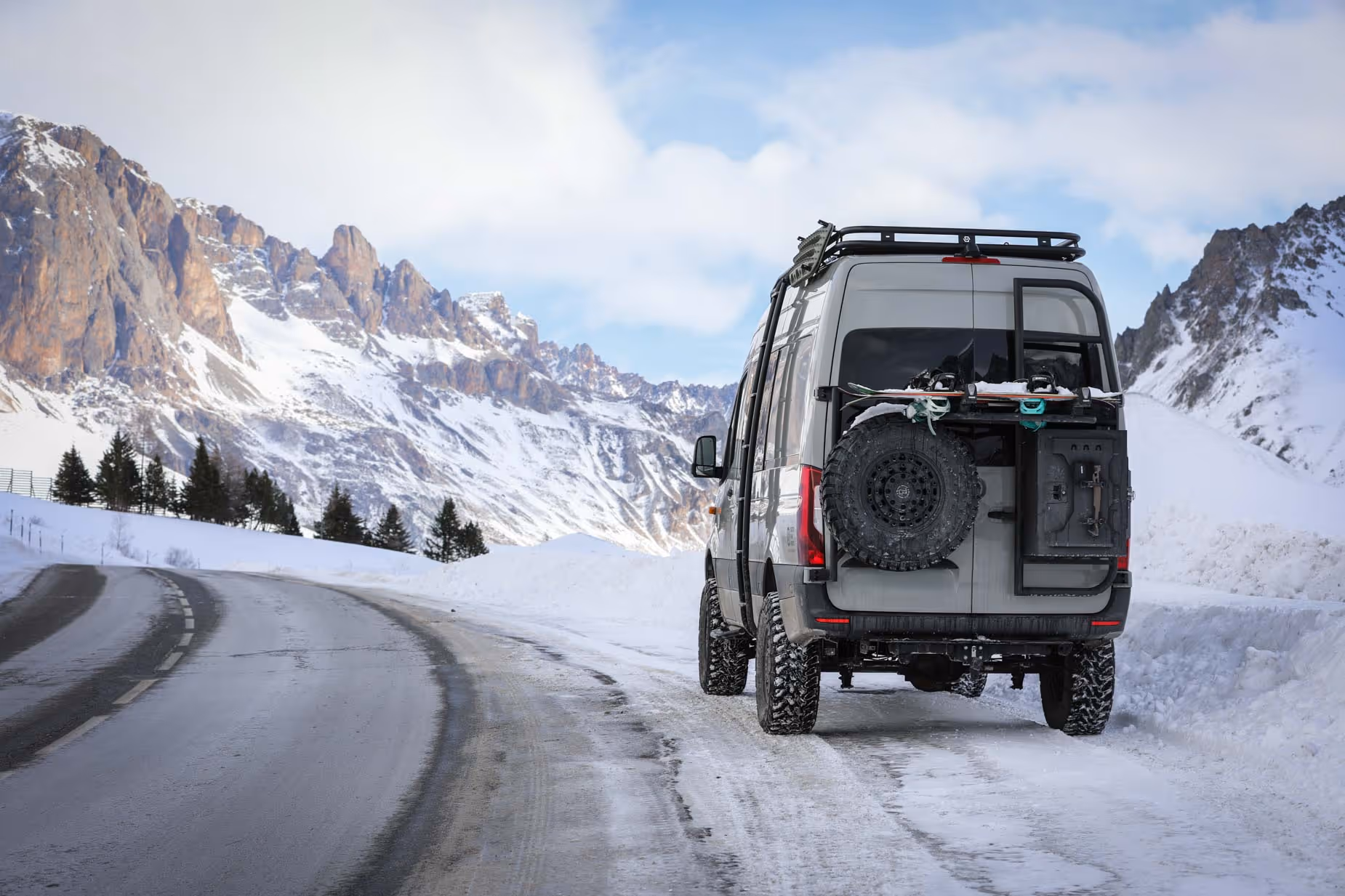 Expedition campervan driving through snowy mountain road