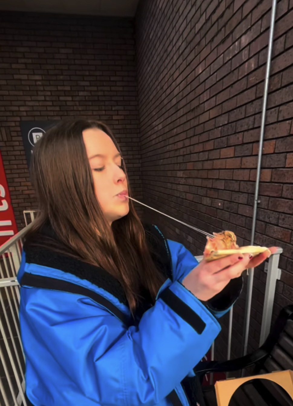 A little boy eating a big pizza and drinking water