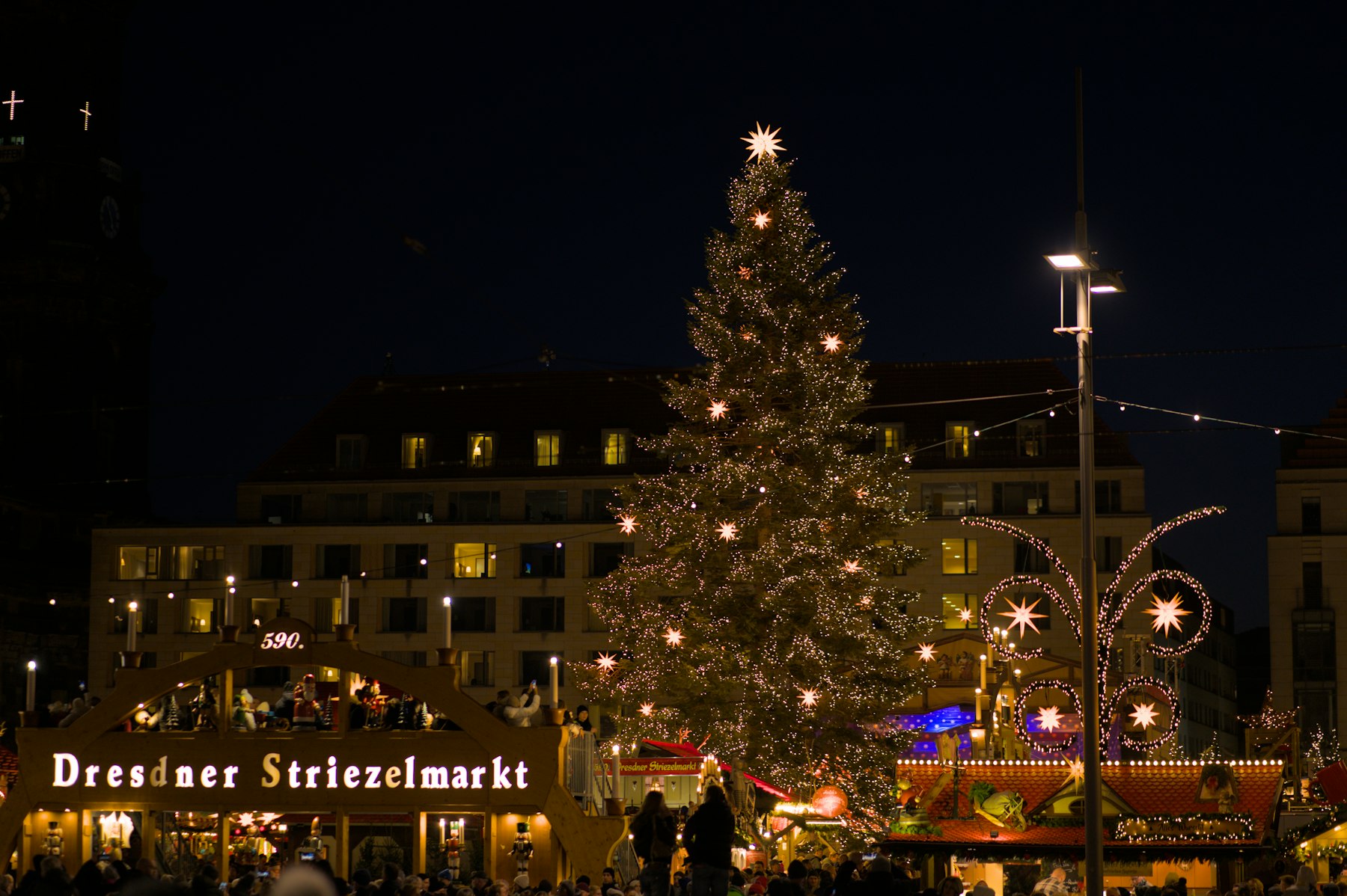 The illuminated Christmas tree and entrance arch of the Striezelmarkt Christmas market in Dresden at night