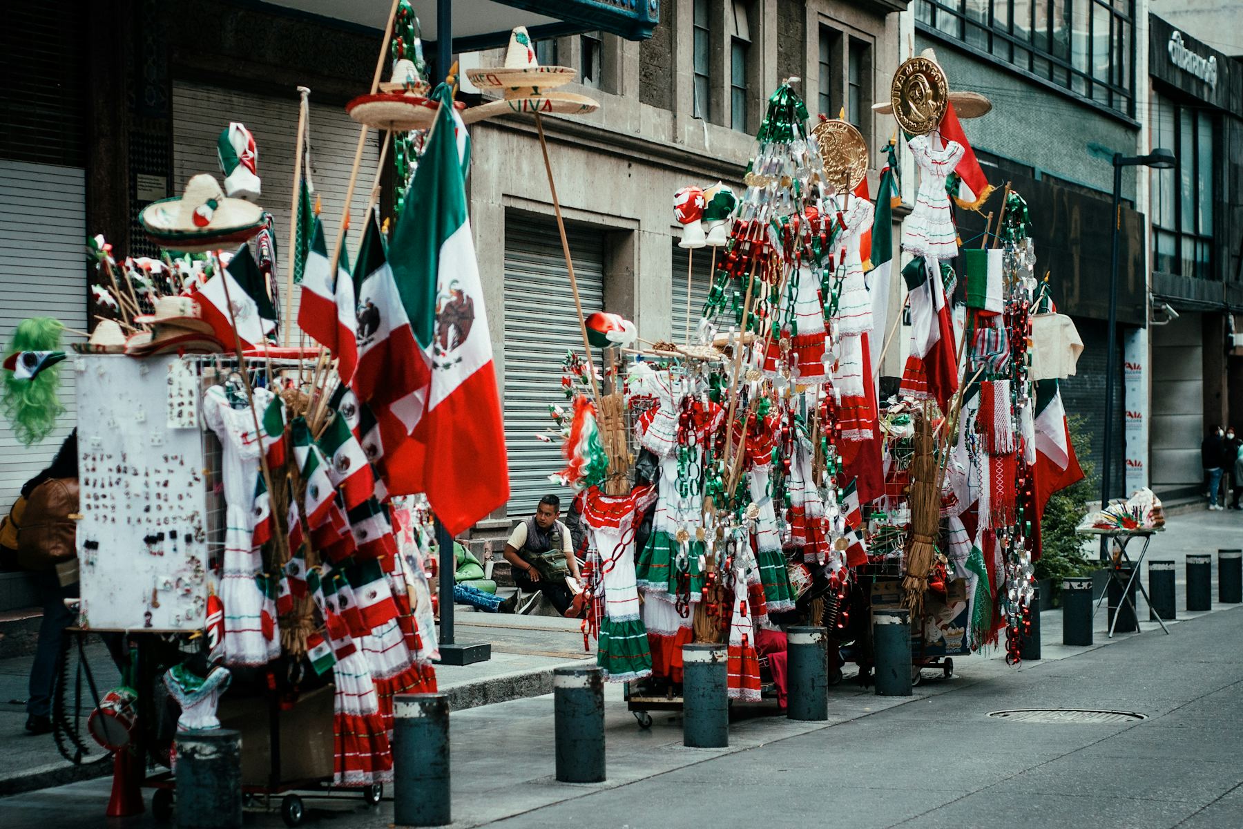 Vendedores ambulantes con banderas mexicanas y adornos patrios antes del Día de la Independencia