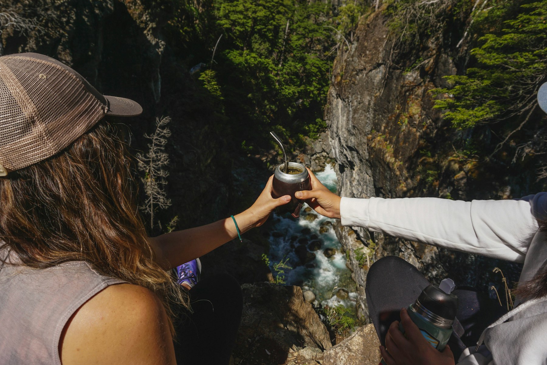 Two friends passing a gourd of mate to each other outdoors
