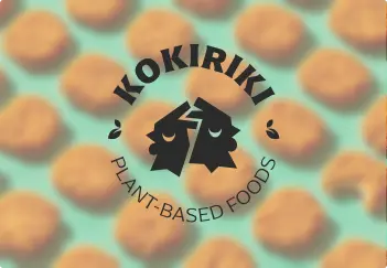 Kokiriki logo on blurred nuggets photograph — brand mark application with warm desaturated food photography