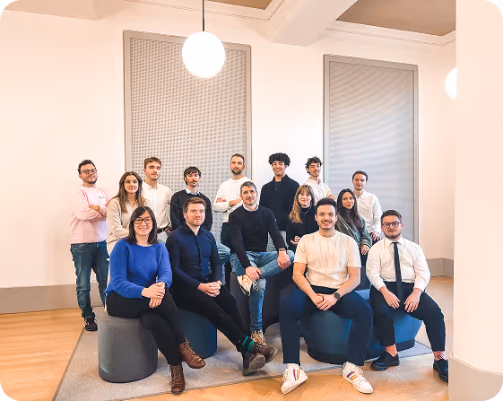 The Pixacare team posing in a bright room with modern furniture.