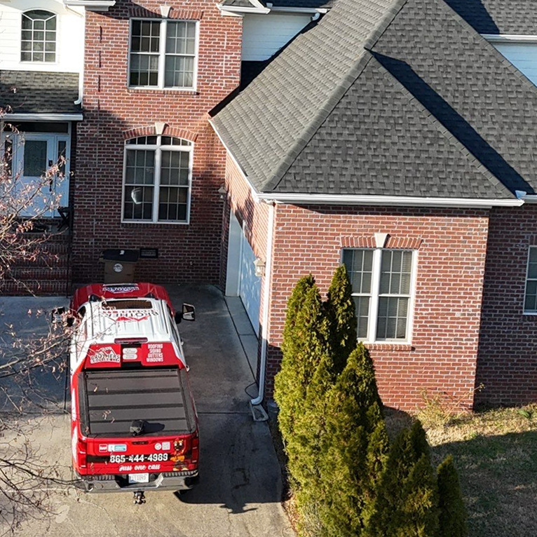 Professional roof inspector examining asphalt shingles up close to identify damage and assess roof condition