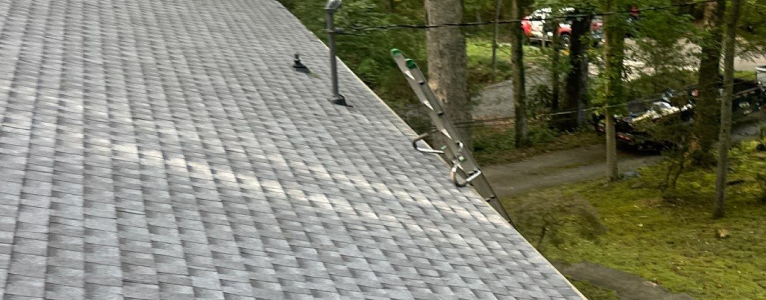 Hail impact damage on shingles marked with irregular chalk circles during roof inspection