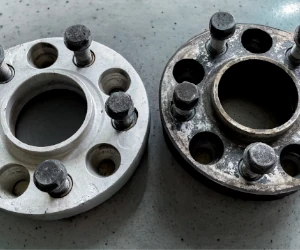 Side-by-side comparison of two metal wheel spacers, one clean and polished on the left, and one rusted and dirty on the right.