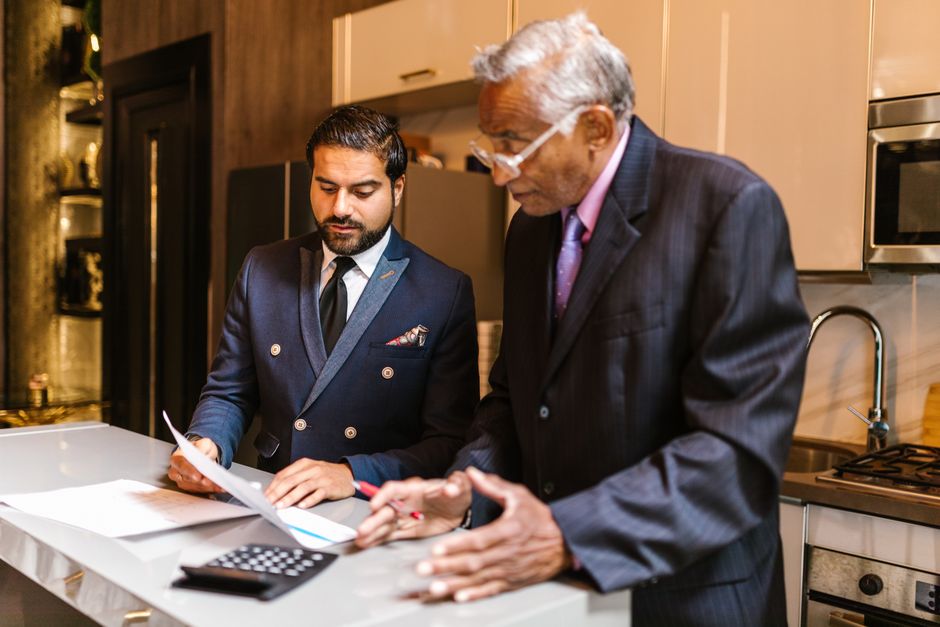Business owner and executive reviewing life insurance benefit plan documents