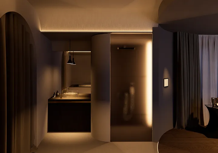 Salle de bain moderne avec éclairage tamisé, lavabo en verre, paroi de douche opaque et rideaux sombres.