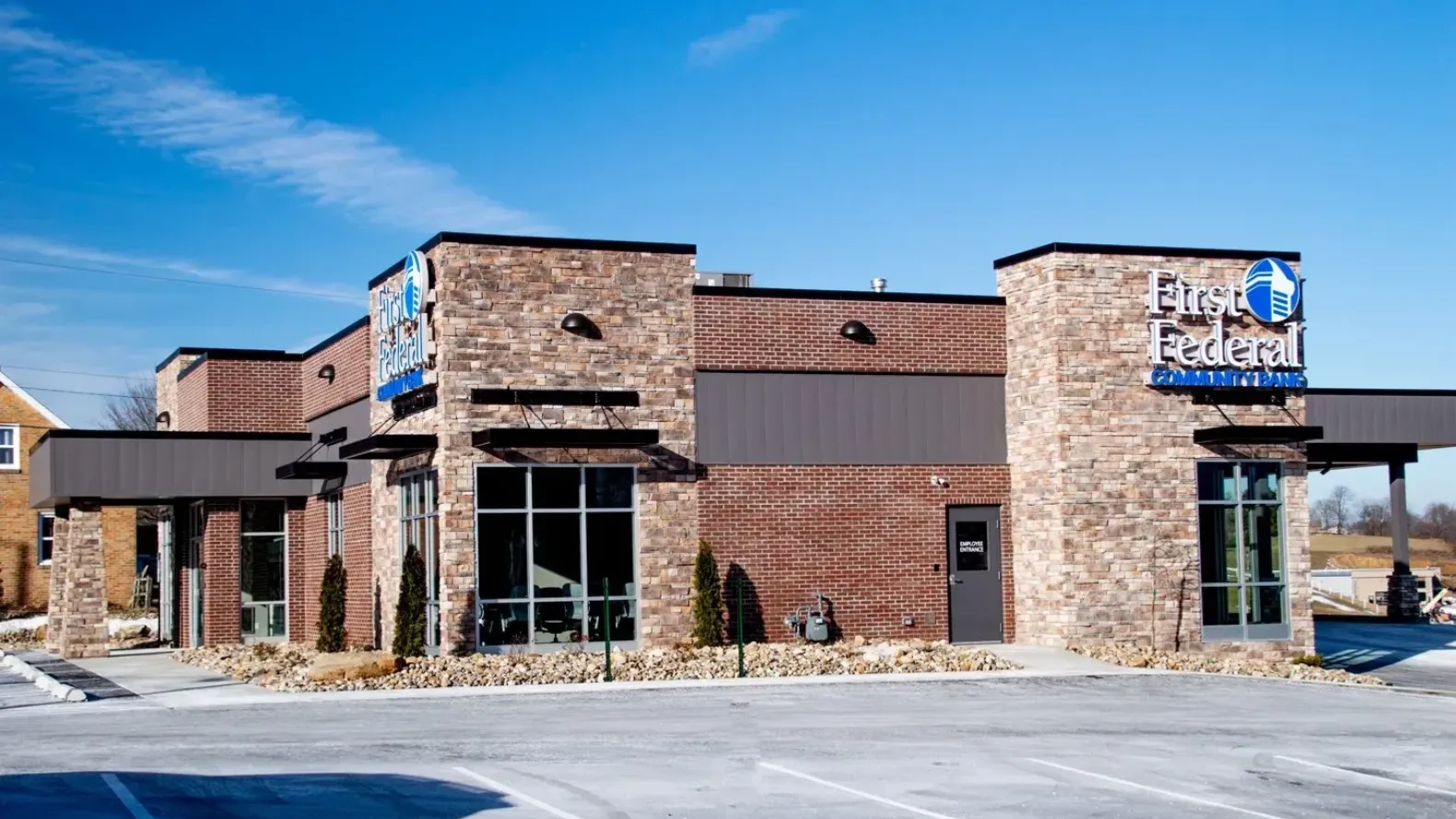 First Federal Community Bank drive-through branch with stone and brick exterior and covered drive-up lanes