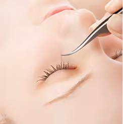 Close-up of a person receiving eyelash extension application.
