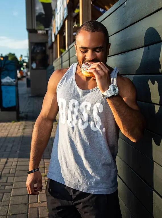 Corey enjoying a donut outside in the sun