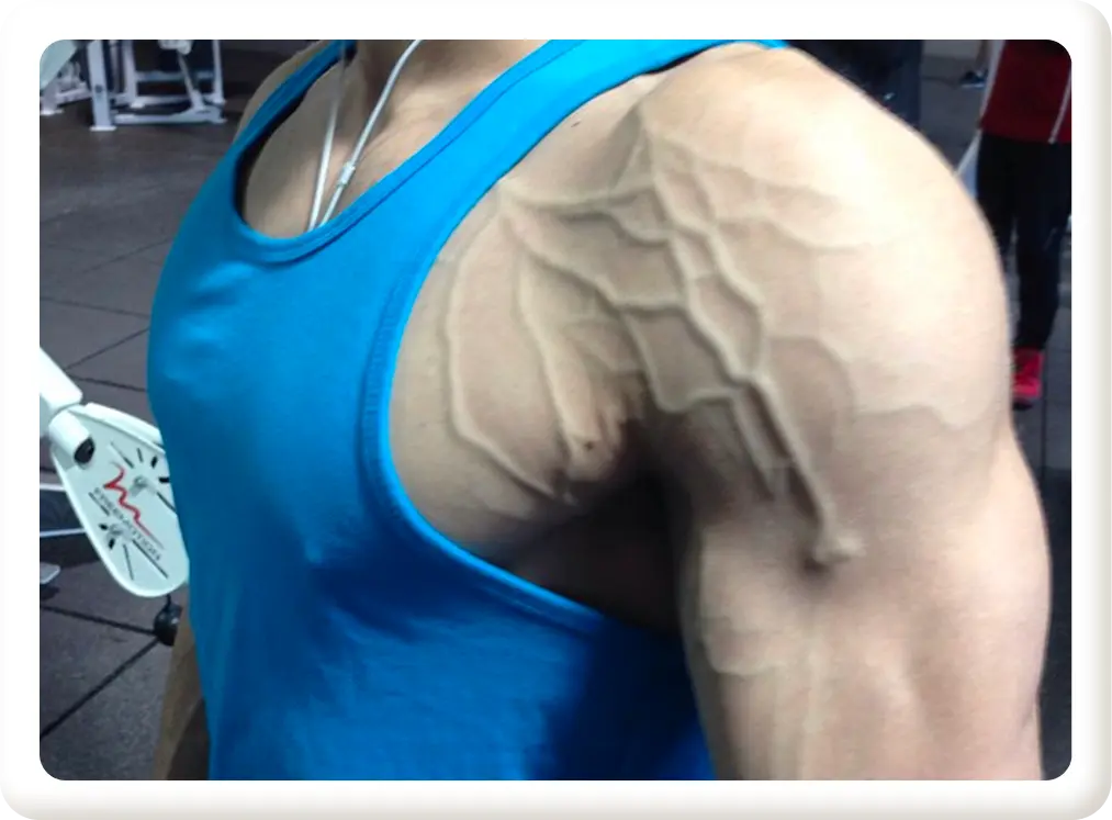 Kyle showing off vascular arms in the mirror at the gym