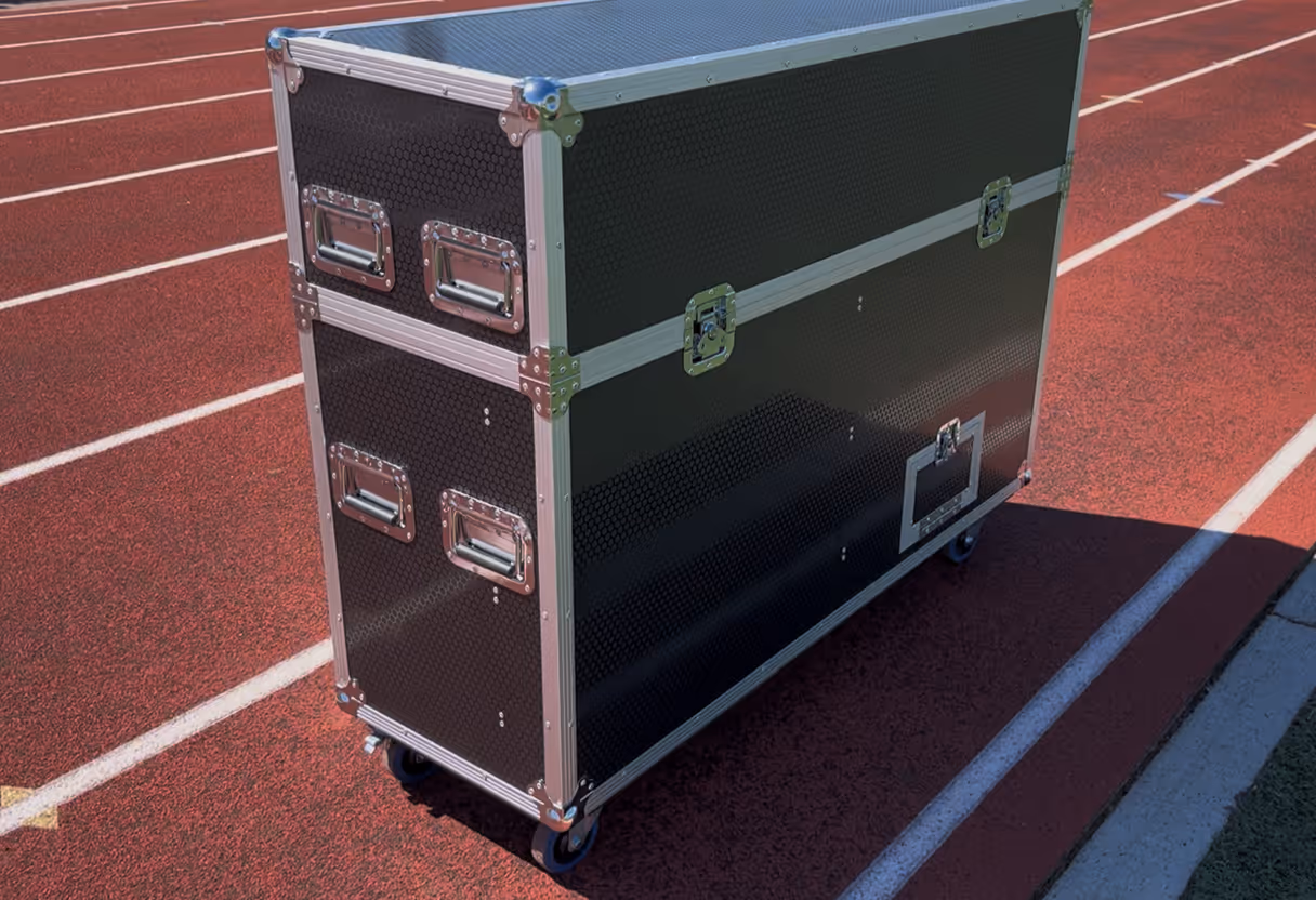 Large equipment transport case with metal edges and handles for a sideline TV to review instant replays.