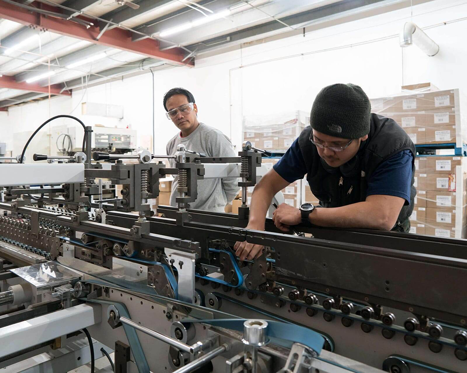 An image of two men performing maintenance on a machine.