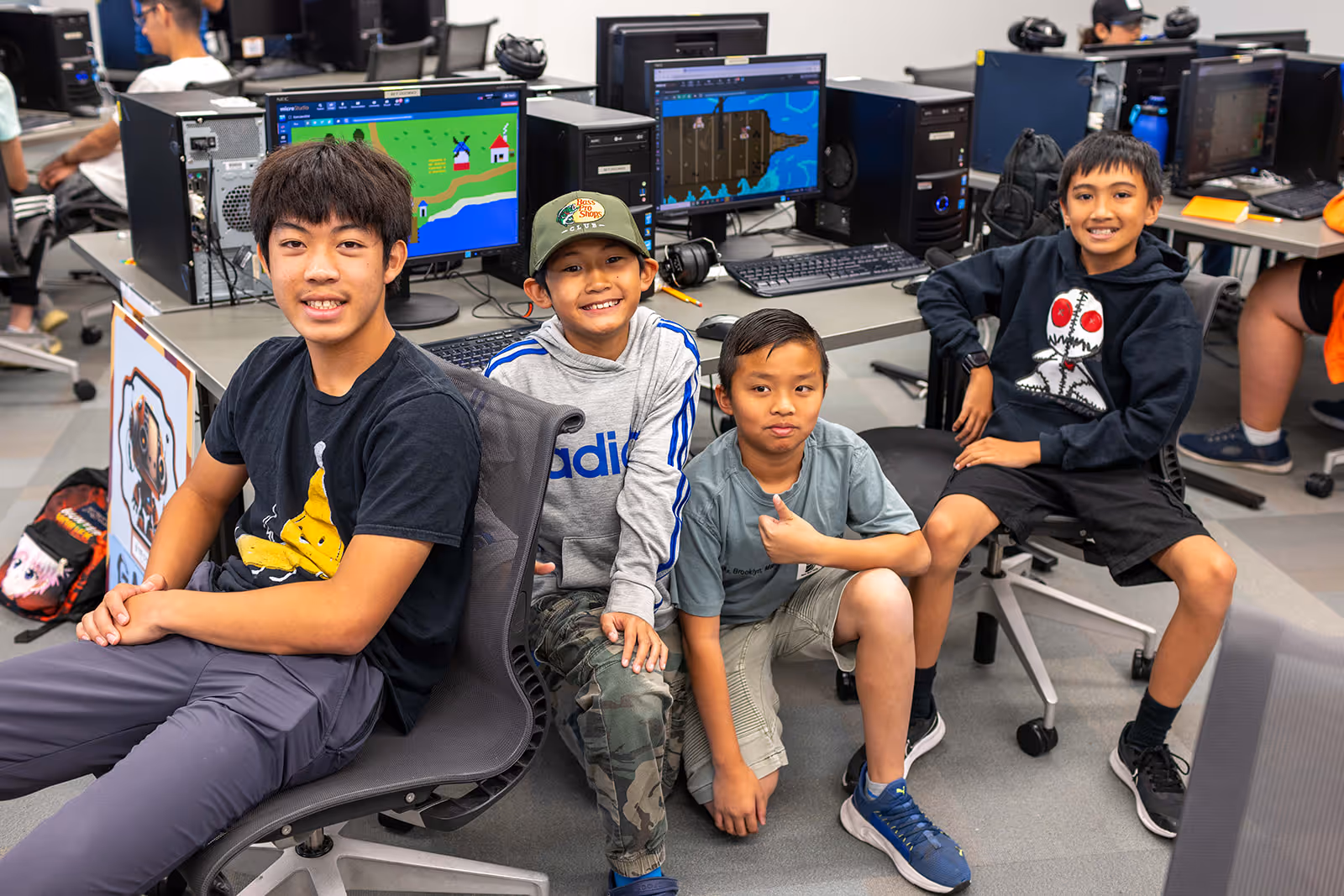 Boy working on a cardboard electronics project labeled 'Let it go' on a classroom table.