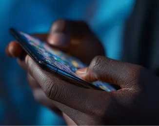 Close-up of hands holding and interacting with a smartphone with colorful app icons on screen.