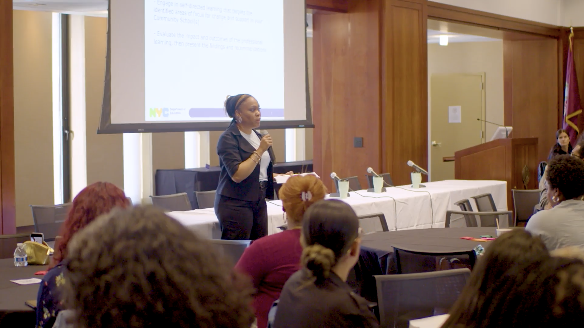 Presenter speaking to seated audience during conference panel event