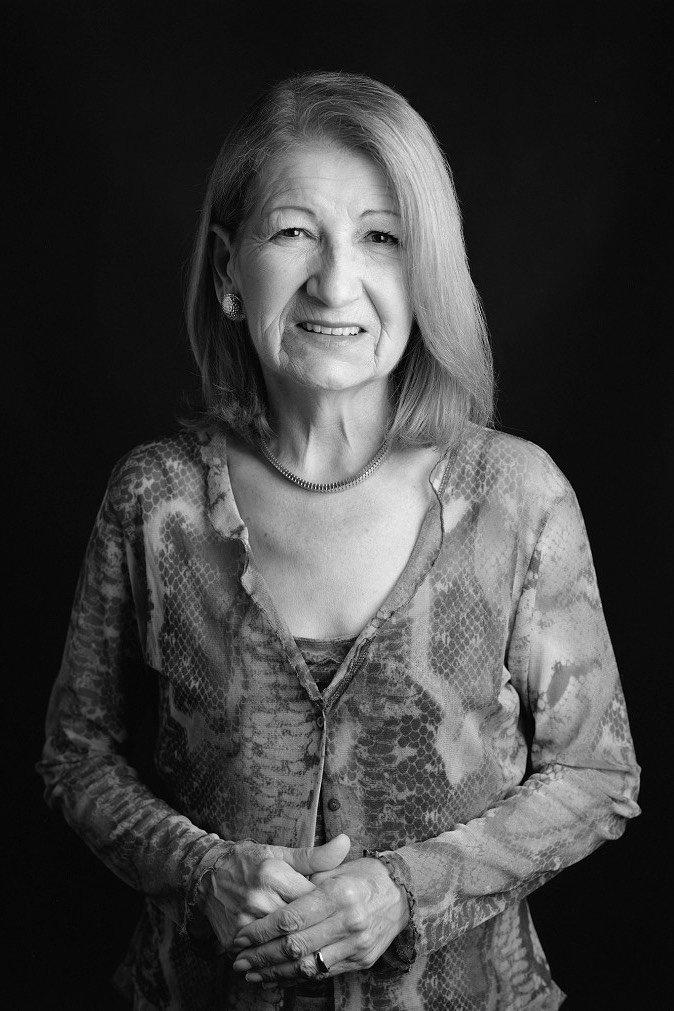 Woman with her hands together in a dark background