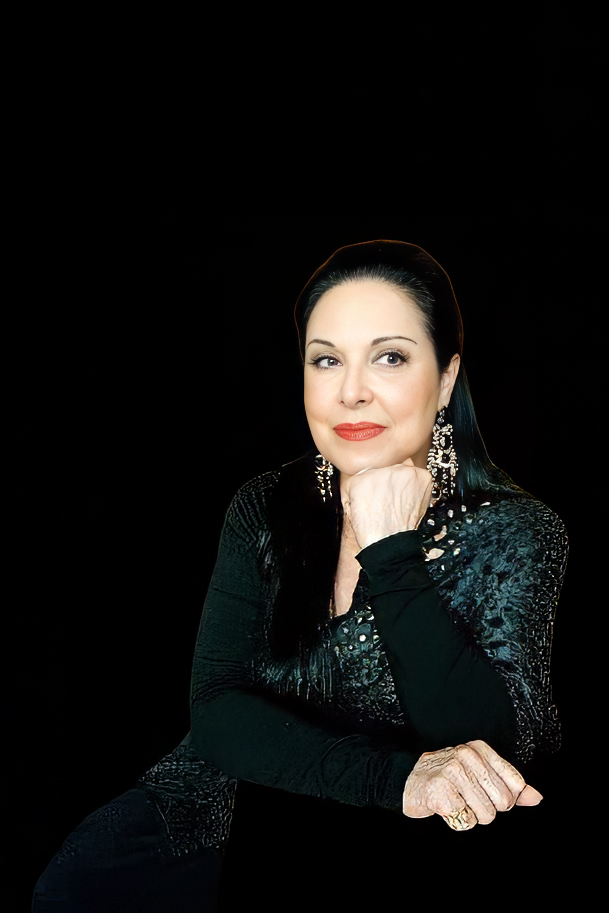 Woman sitting with a hand her chin in a dark background