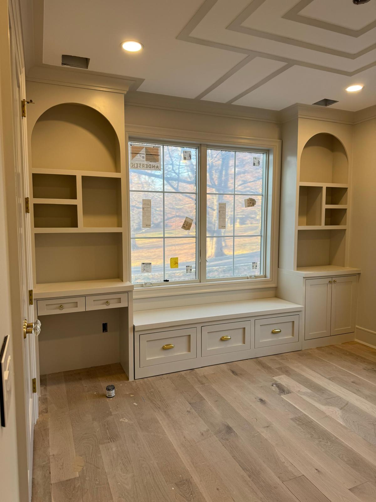 Custom built-in shelving, desk, and window seat with a coffered ceiling in a New Jersey room