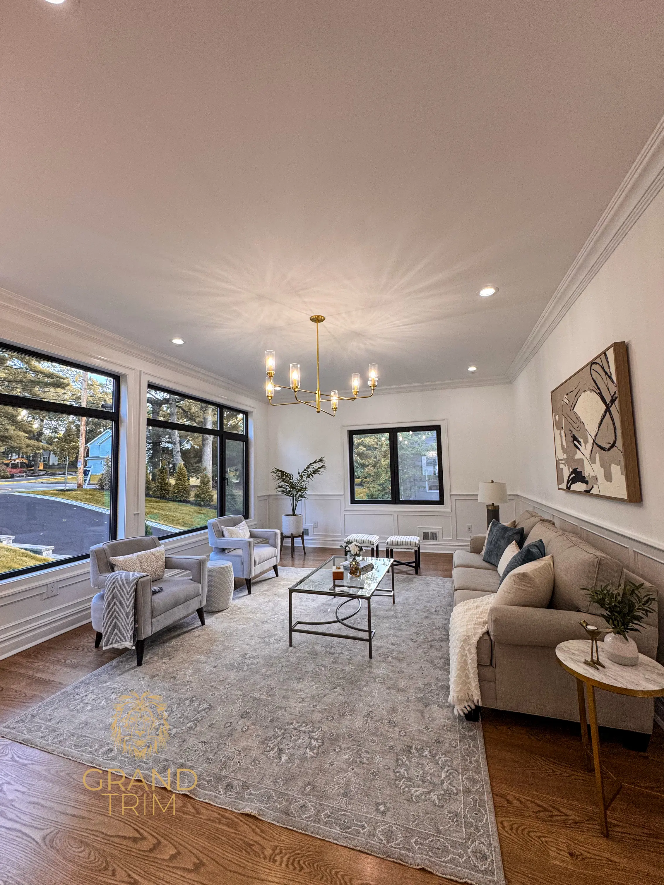 White wainscoting and elegant crown molding in a bright living room in New Jersey