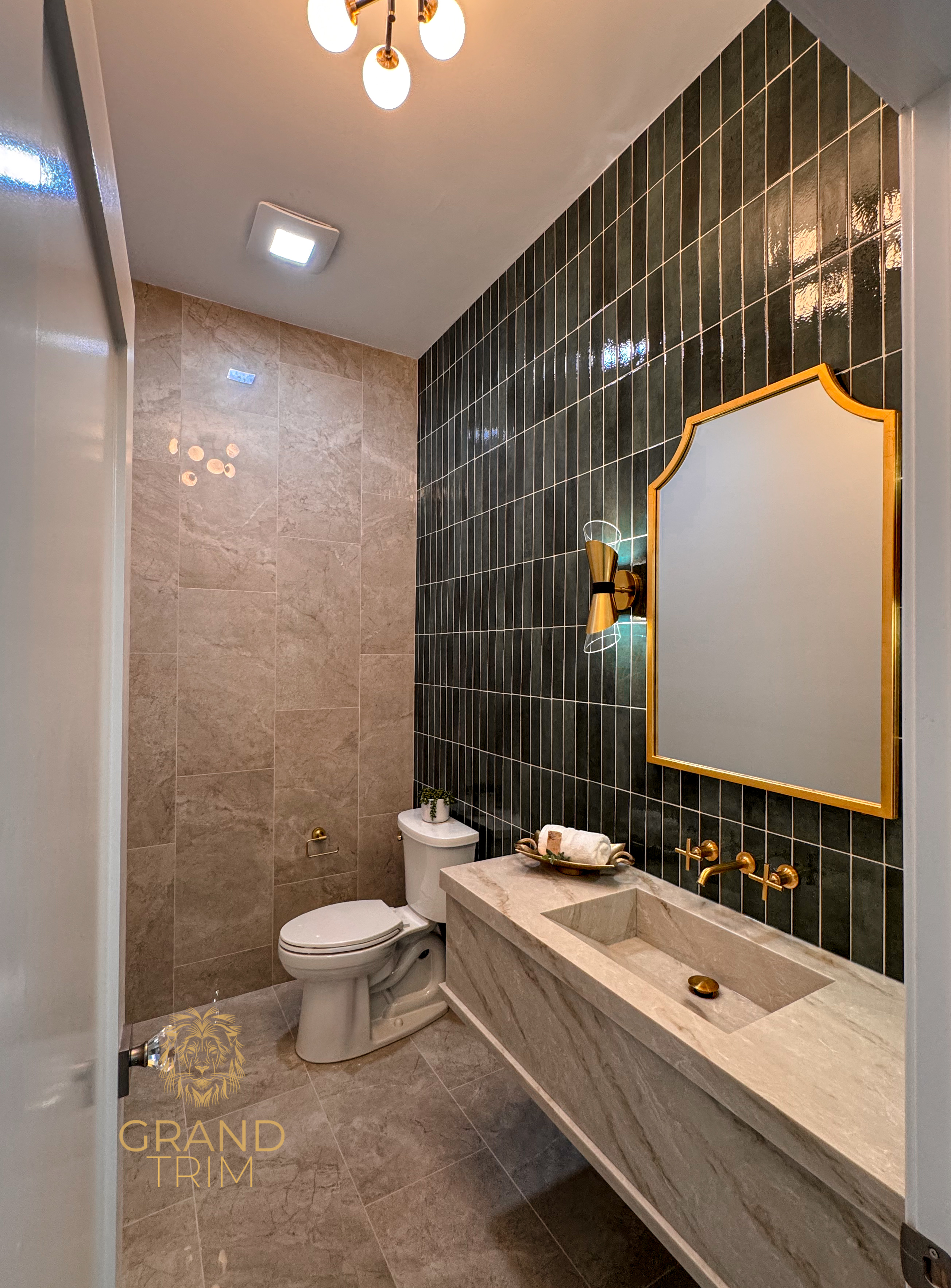 Custom built-in vanity with integrated sink and dark tiled wall in a New Jersey powder room