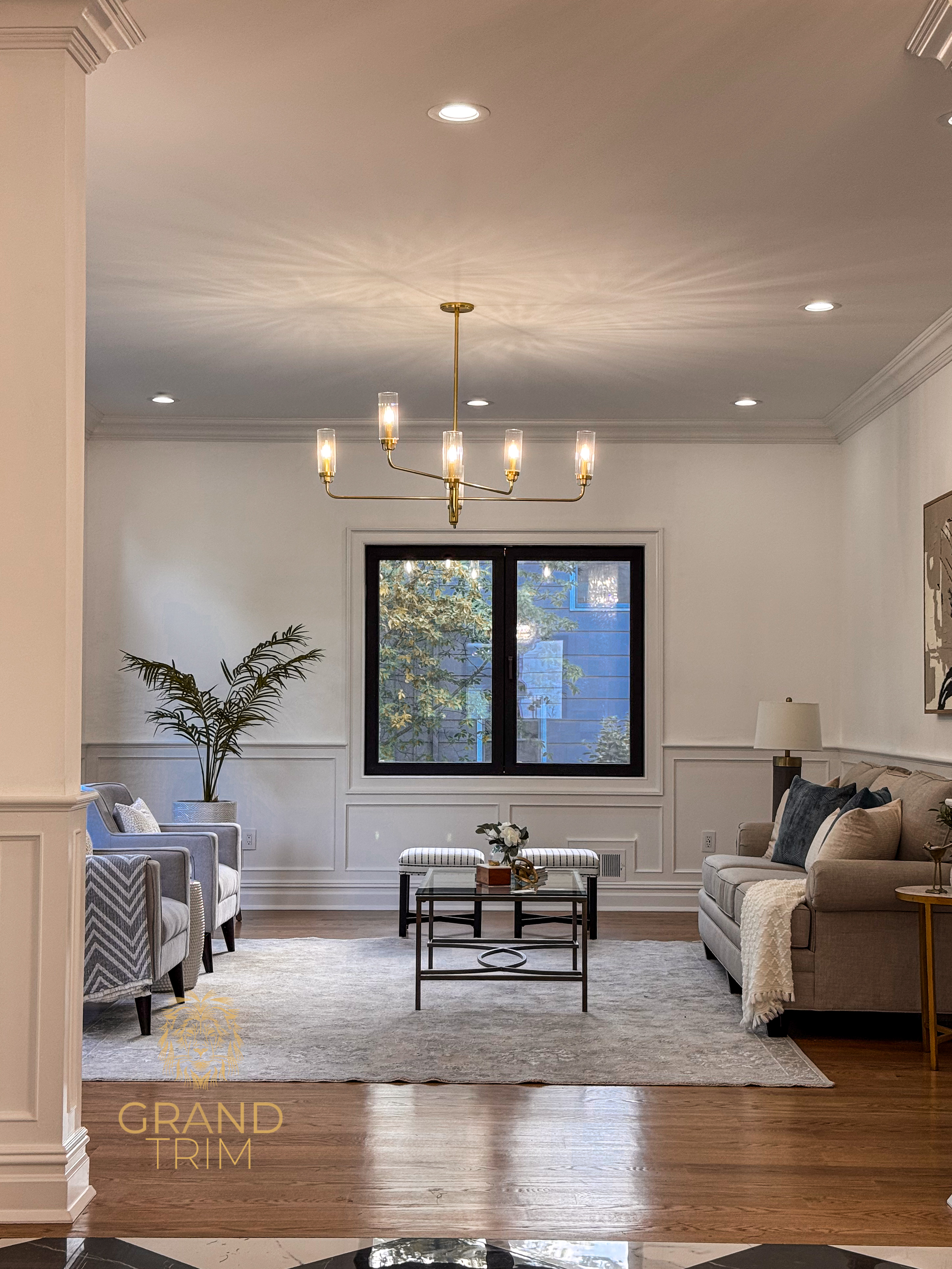 White wainscoting and elegant crown molding in a modern living room in New Jersey
