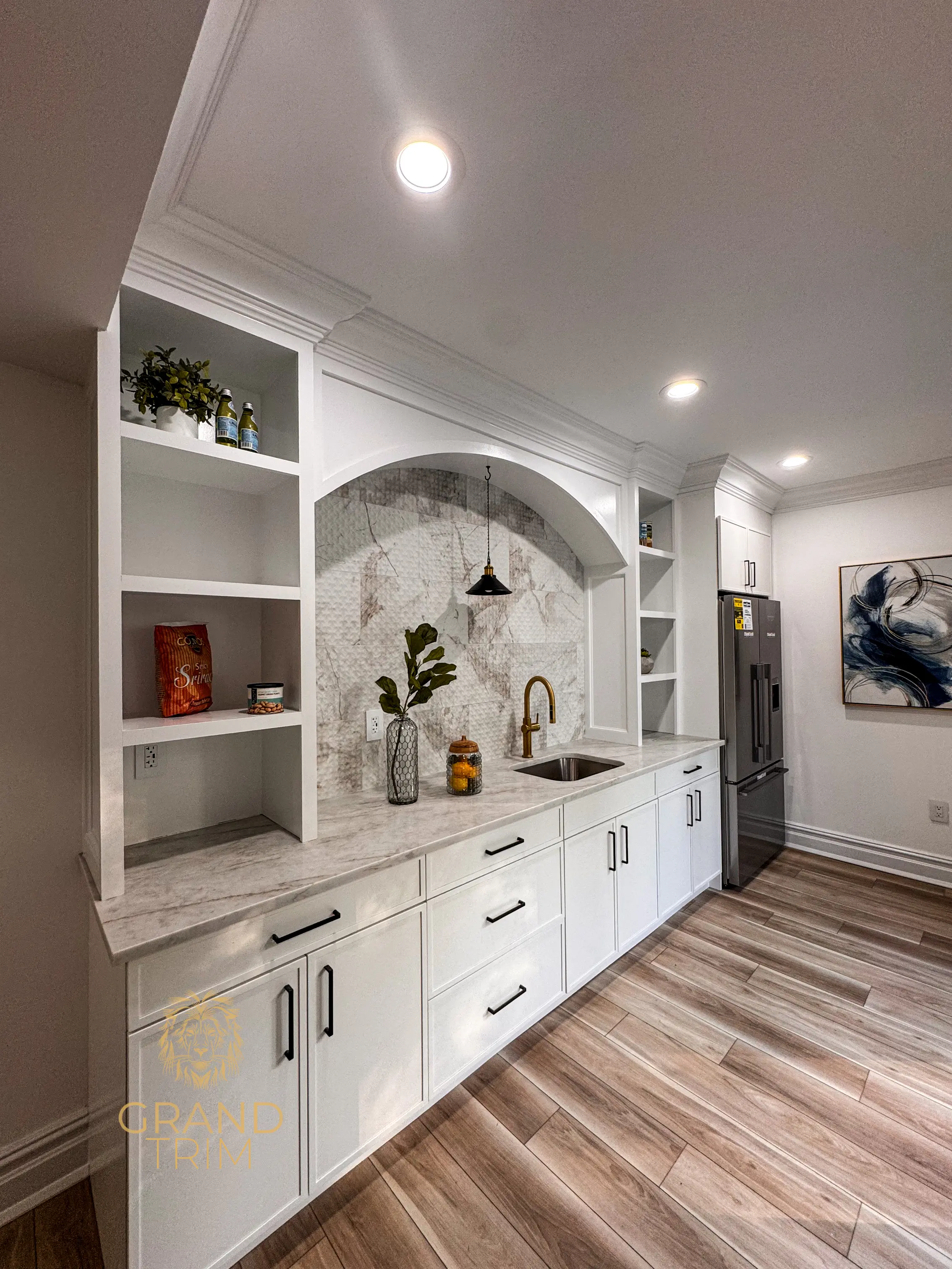 White custom built-in wet bar with marble countertop, sink, and refrigerator in NJ.