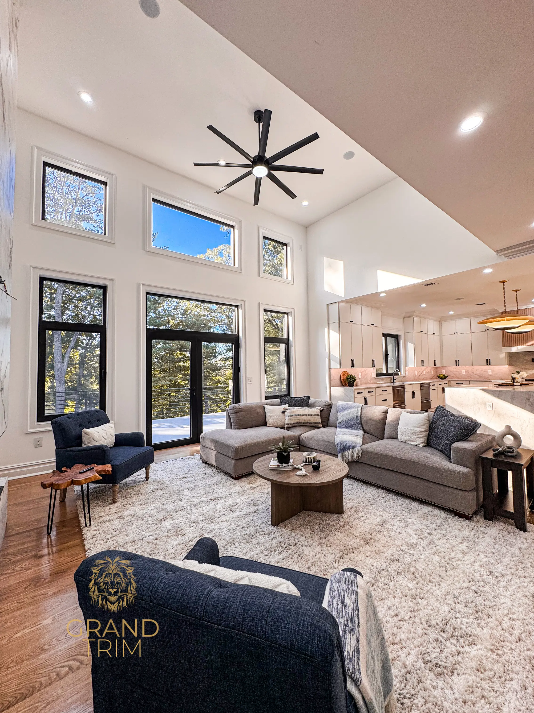 White window and door trim in a modern open-concept living room with a kitchen featuring custom white cabinetry in NJ.
