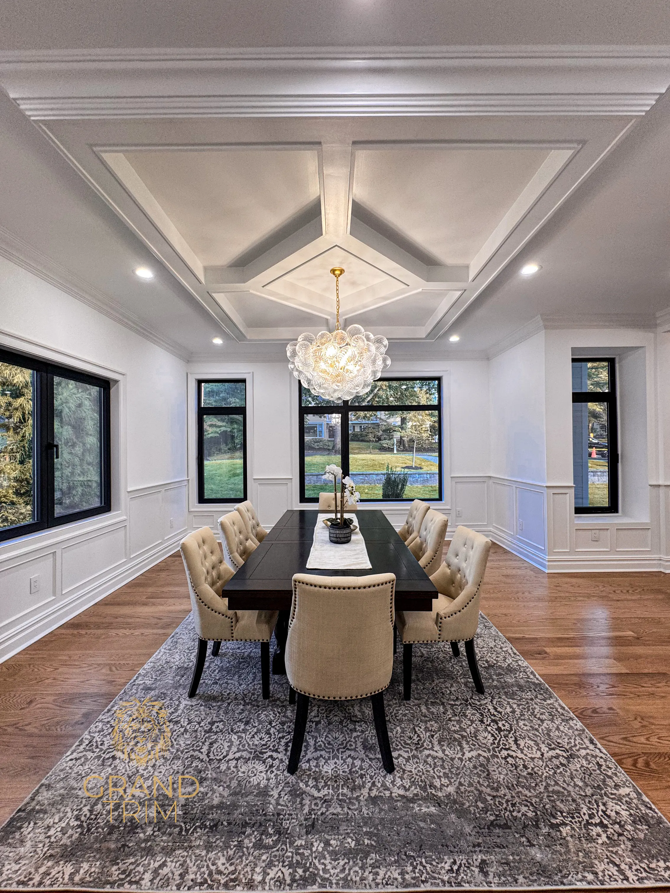 White coffered ceiling with intricate trim and wainscoting wall panels in a NJ dining room