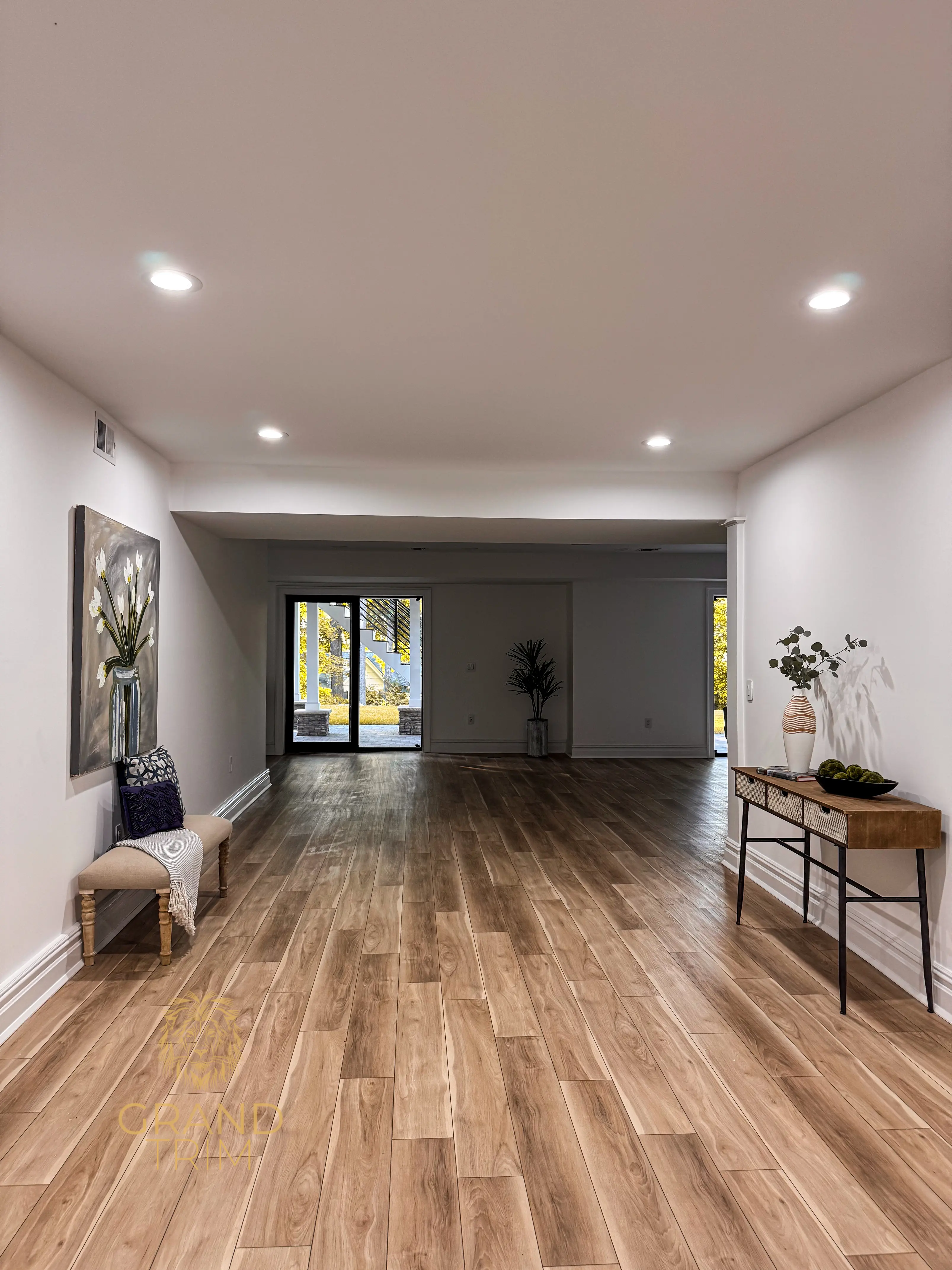Smooth white baseboard trim installation along walls in a bright, modern hallway in New Jersey